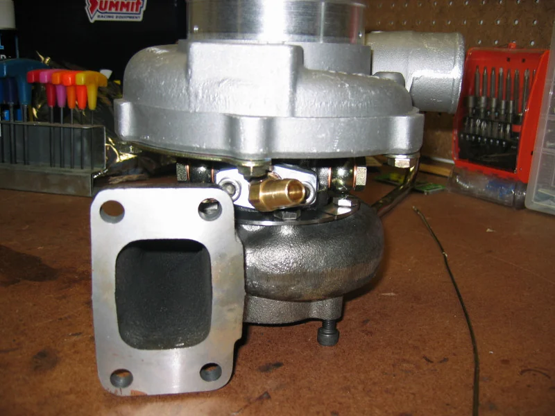 Assembled Garrett GT30 CHRA, front view, showing the turbine inlet flange and oil-feed banjo fitting — real reference photograph