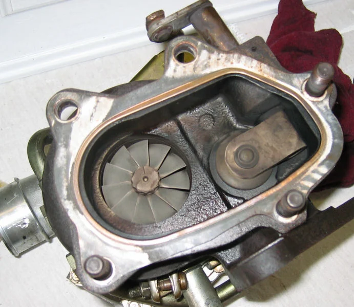 Internal wastegate flapper valve on its seat, IHI VF39 turbine housing with outlet cover removed — real reference photograph